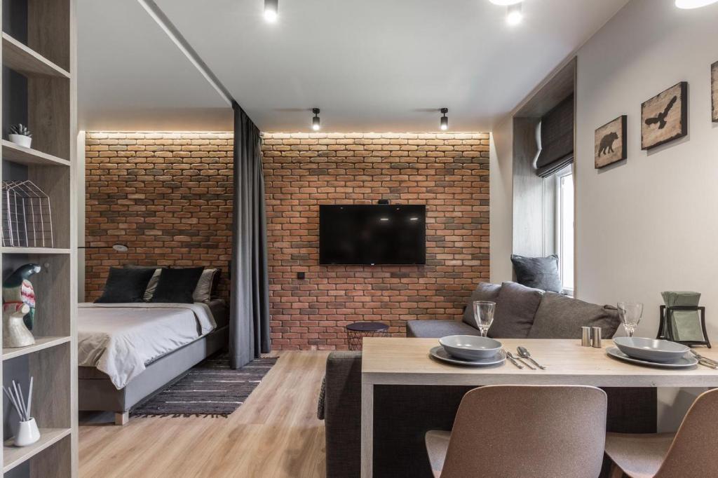 a living room with a bed and a brick wall at S7 Apartment in Rīga