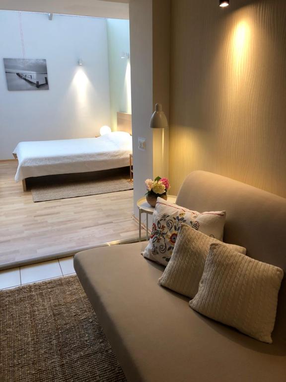 uma sala de estar com uma cama e um sofá com almofadas em NIDALIVING Romantic Apartment Under the Stars em Nida