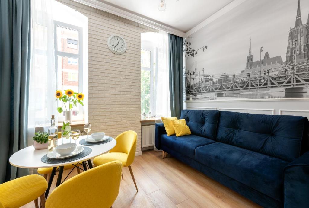 un soggiorno con divano blu e tavolo di Apartament Francuski a Breslavia