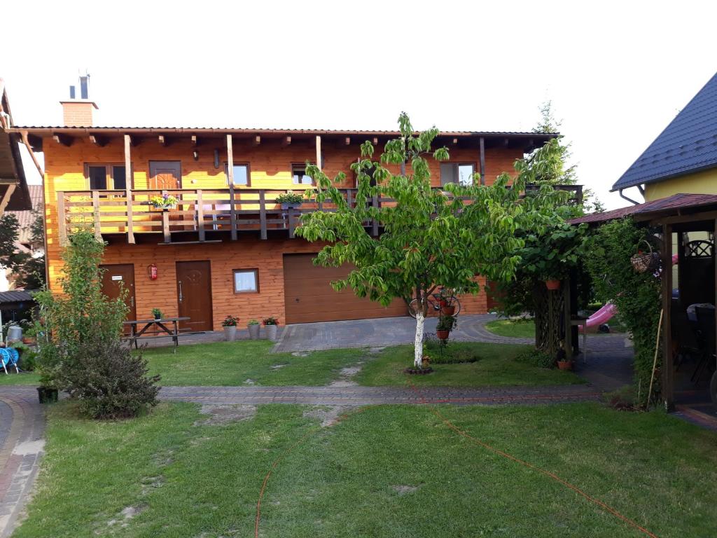 a house with a tree in front of it at Pokoje U Anny i Łukasza in Swornegacie 