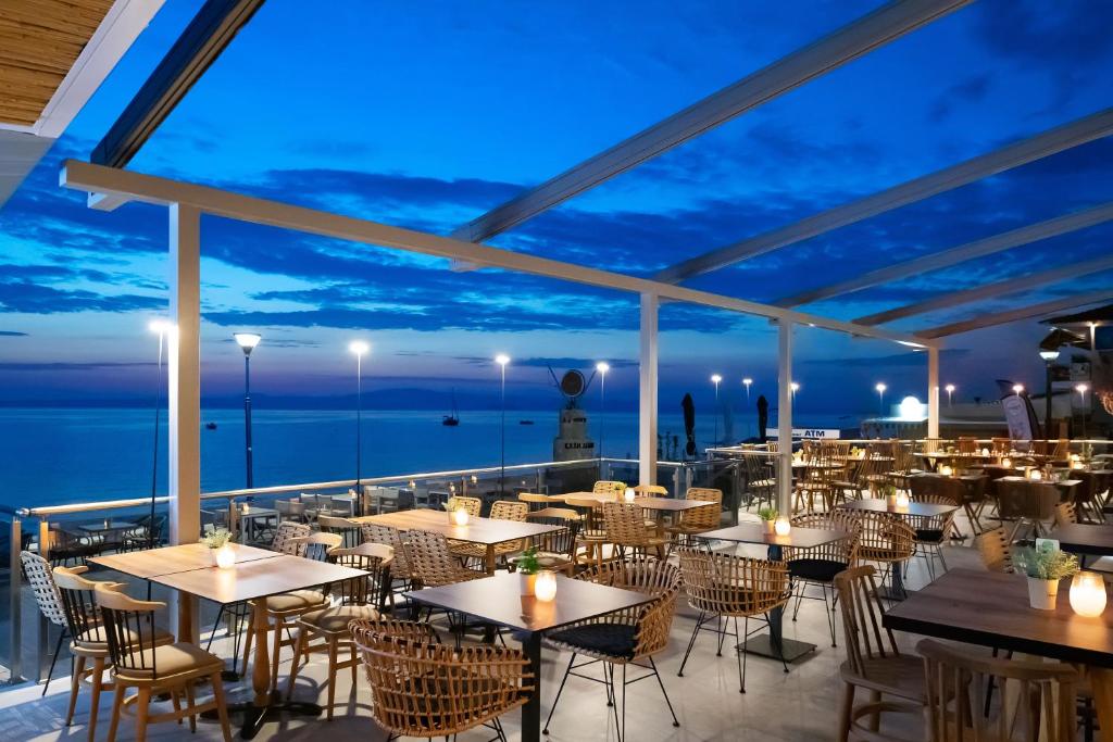 um restaurante com vista para o mar à noite em Sea Level Hotel - Adults Only 16 plus em Polykhrono