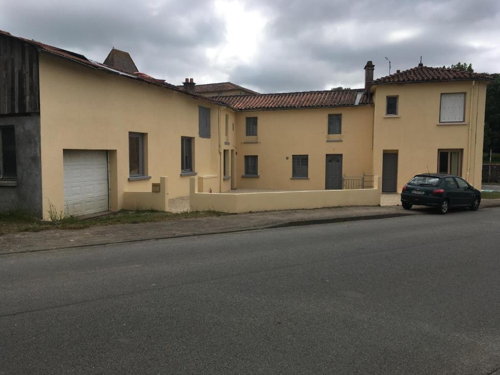 un edificio con un coche estacionado al lado de una calle en Le gîte du manoir, en Réaumur