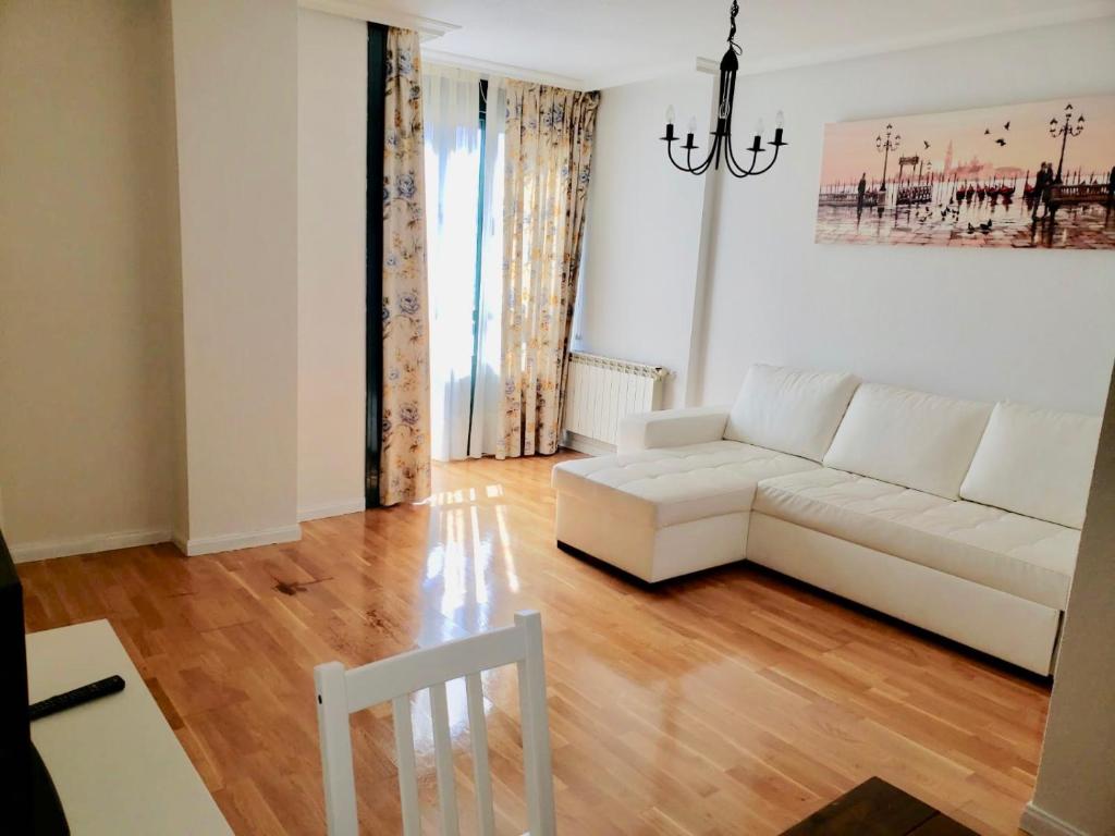 a living room with a white couch and wooden floors at Roxy 1 in Avila