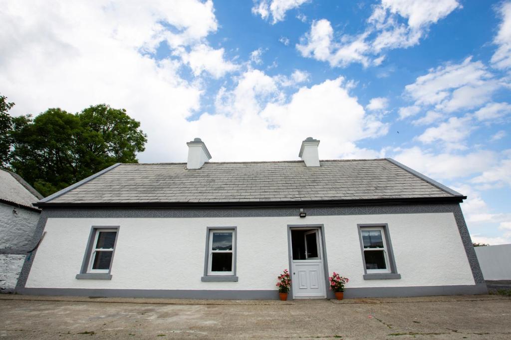 una casa blanca con techo en Mary's Cosy Cottage on the Wild Atlantic Way, en Galway