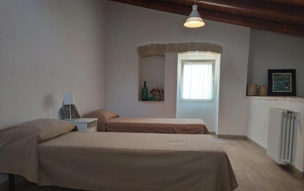 une chambre avec deux lits et une fenêtre dans l'établissement LA CASETTA 6058, à Conversano