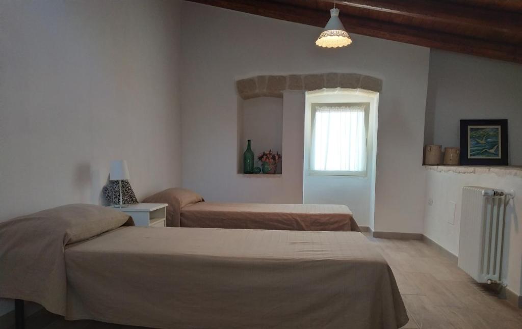 a bedroom with two beds and a window at LA CASETTA 6058 in Conversano