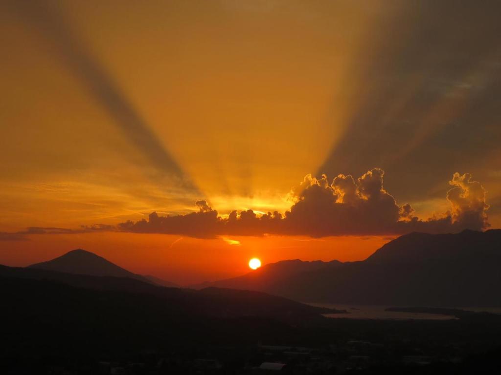 um pôr-do-sol com o pôr-do-sol atrás das montanhas em Raj em Kotor
