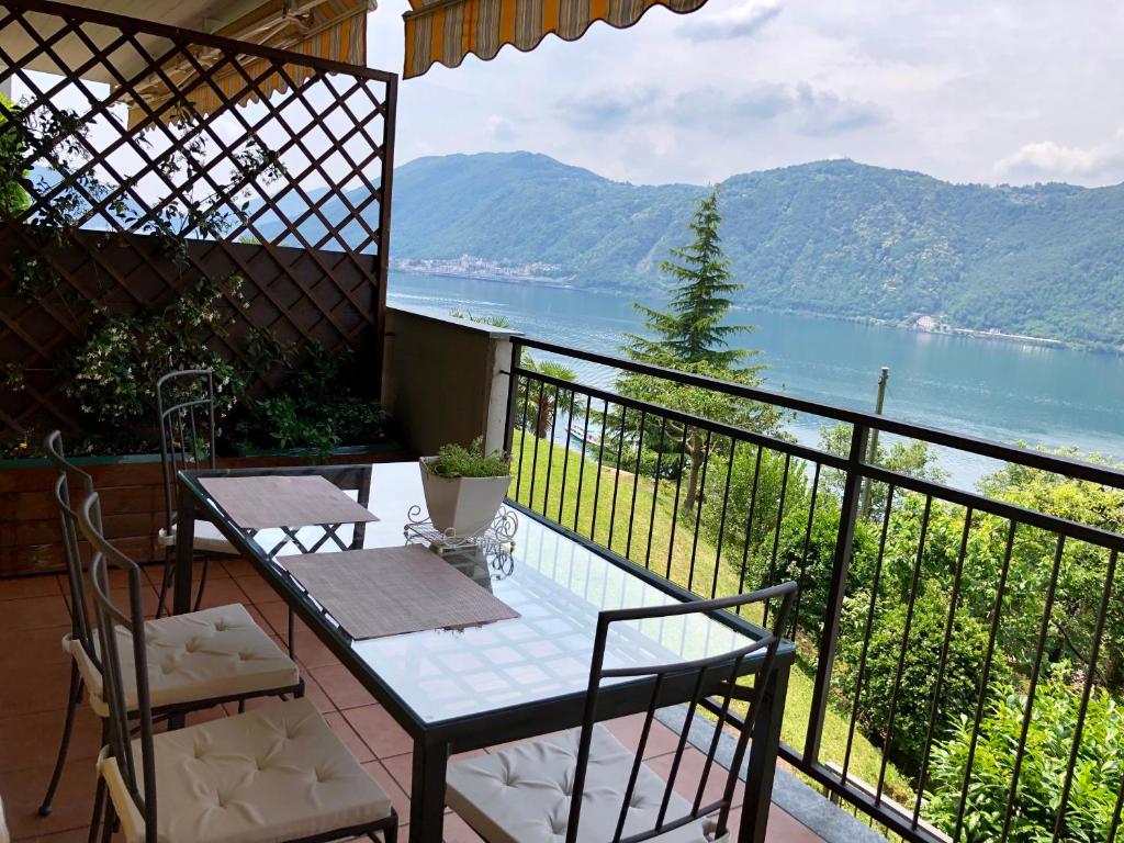 un tavolo e sedie su un balcone con vista sull'acqua di appartamento con bellissima vista a Campione dʼItalia
