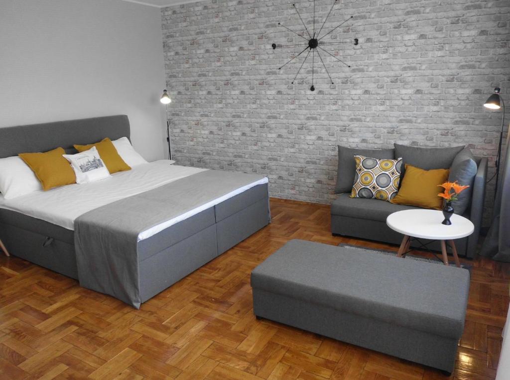 a bedroom with a large bed and a couch at Ares Apartments in Przemyśl