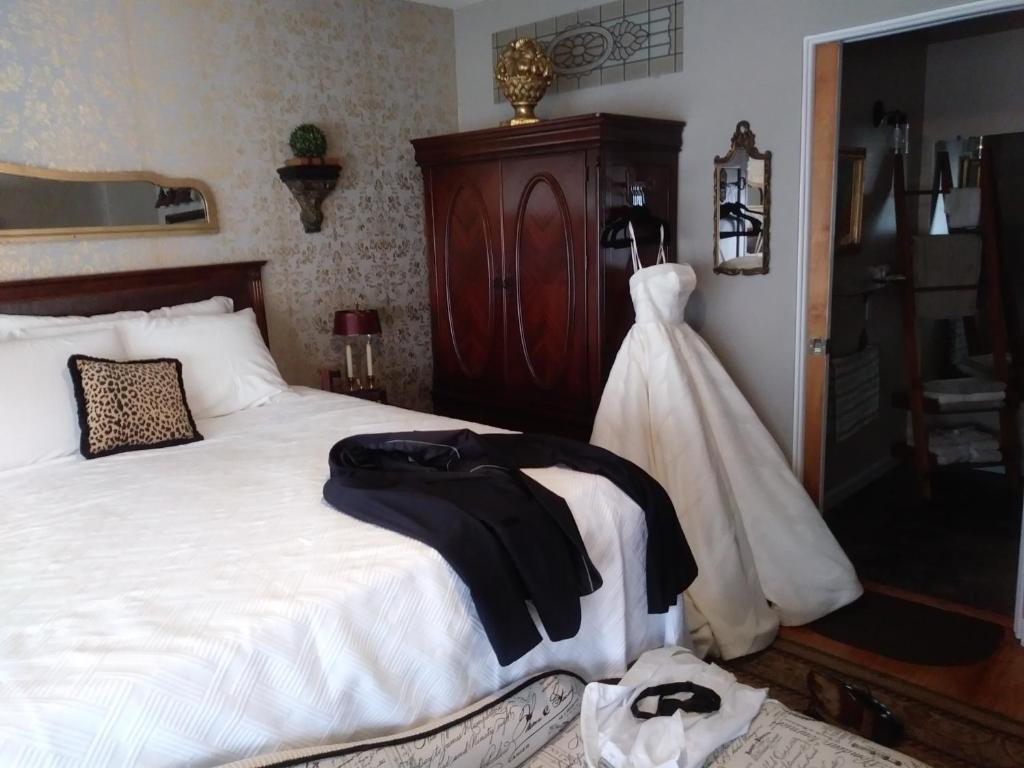 a bedroom with a bed with a wedding dress on it at The guest house at the regina house tea room in Moosic