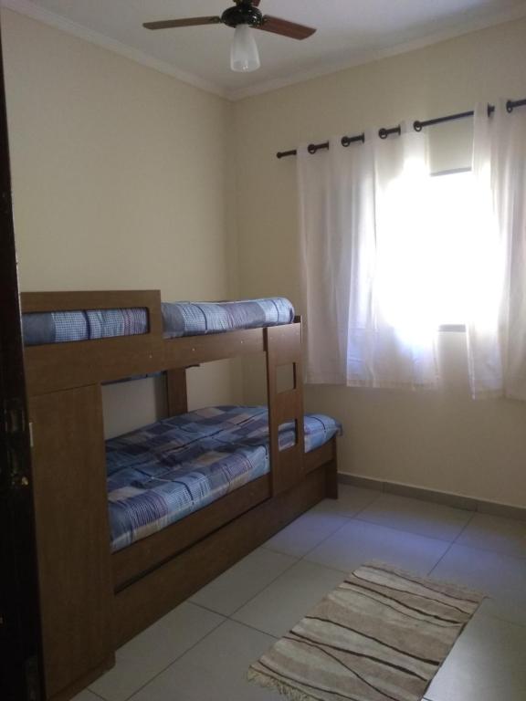 a bedroom with two bunk beds and a window at Casa aconchegante próxima a Basílica! in Aparecida