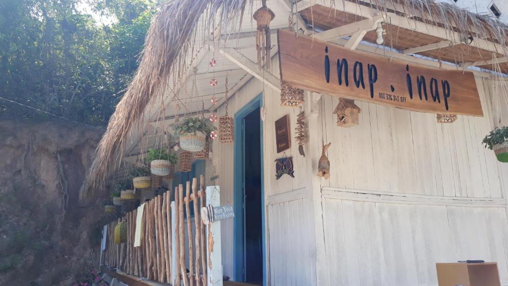 a white building with a sign that says happy hug at Inap.Inap Karimunjawa in Karimunjawa