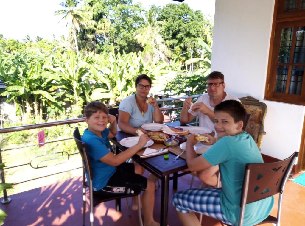 a group of people sitting at a table eating food at Senu Relax Home in Polonnaruwa