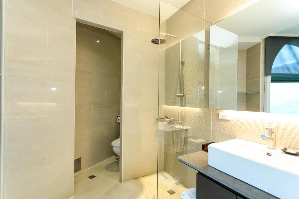 a bathroom with a sink and a glass shower at Yang Ming Shan Tien Lai Resort &amp; Spa in Jinshan