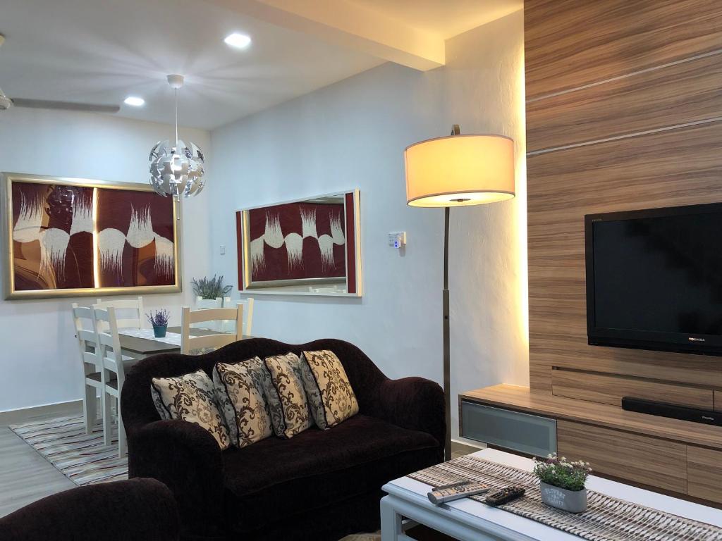uma sala de estar com um sofá e uma televisão de ecrã plano em Terengganu Guest House em Kuala Terengganu