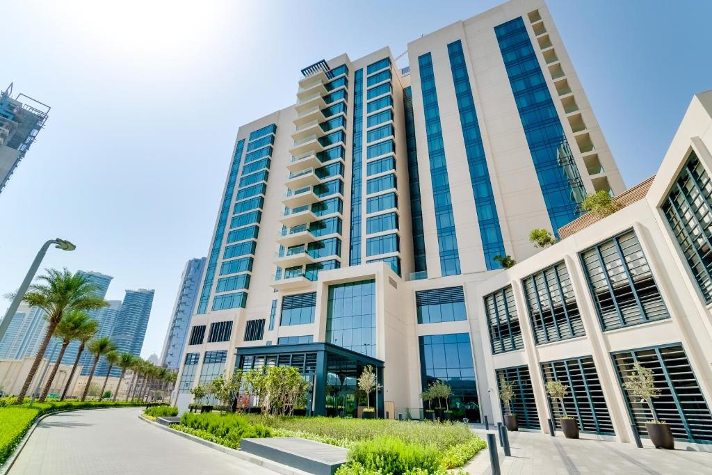 a building in the city with palm trees at Vida Emirates Hills Residences in Dubai