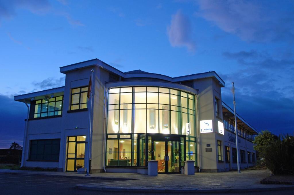 a large building with large glass windows at night at Sefton Express Hotel in Ballasalla