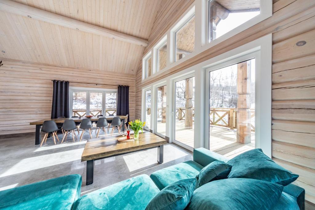 a living room with a blue couch and a table at CHATA POD PRZEHYBĄ in Stary Sącz