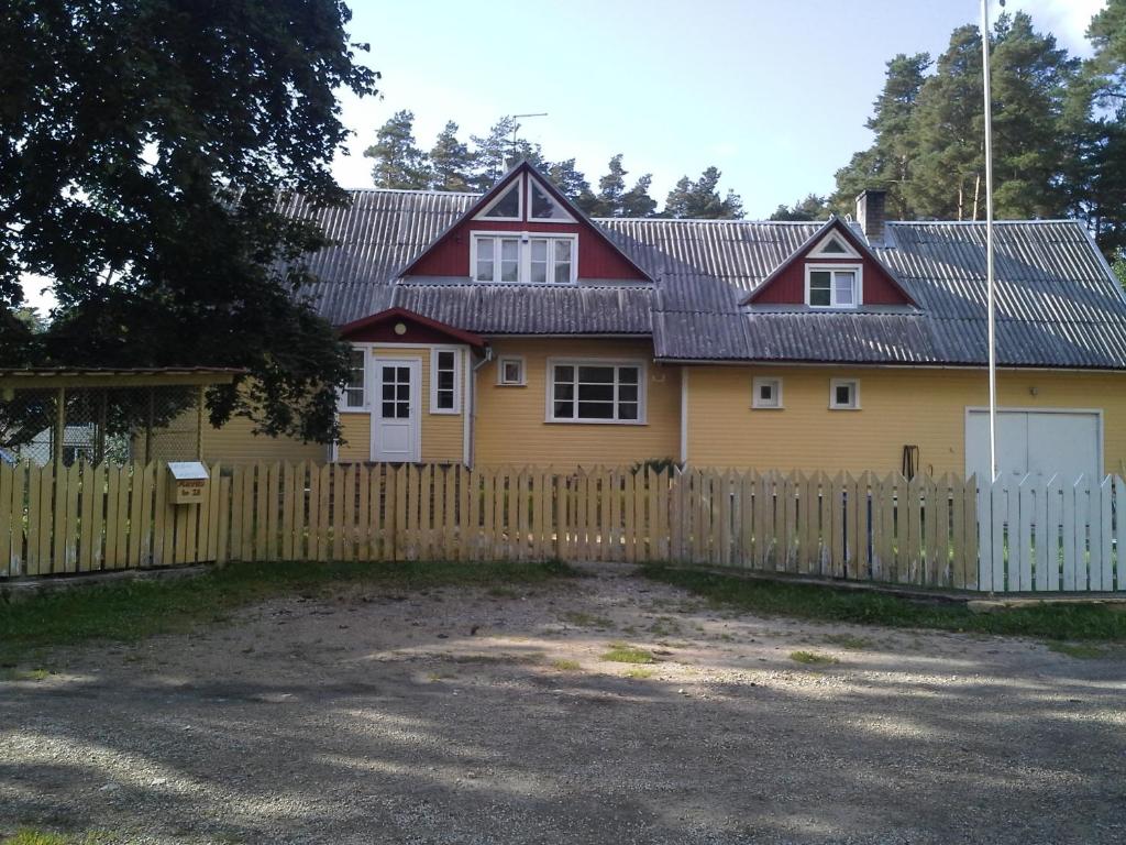 uma casa amarela com uma cerca em frente em Koidu Homestay em Haapsalu