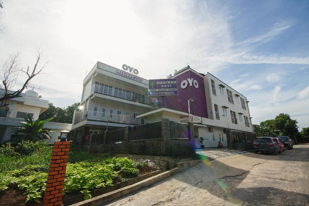 a large building with a sign on top of it at Super OYO 270 Madinah Residence Syariah in Talang Kelapa