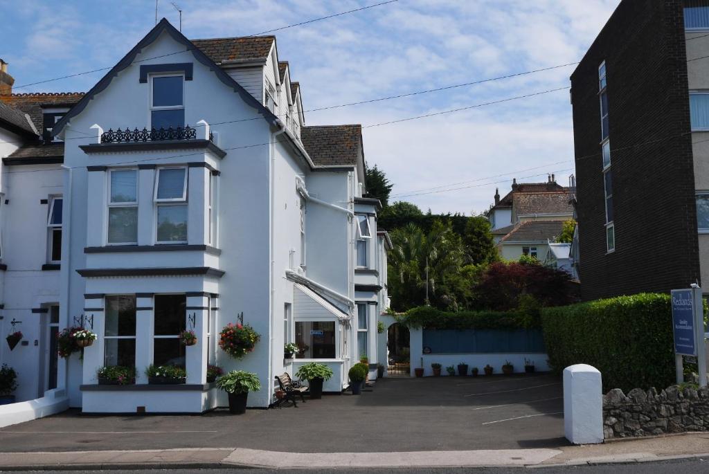 uma casa branca com muitas janelas em Redlands em Brixham