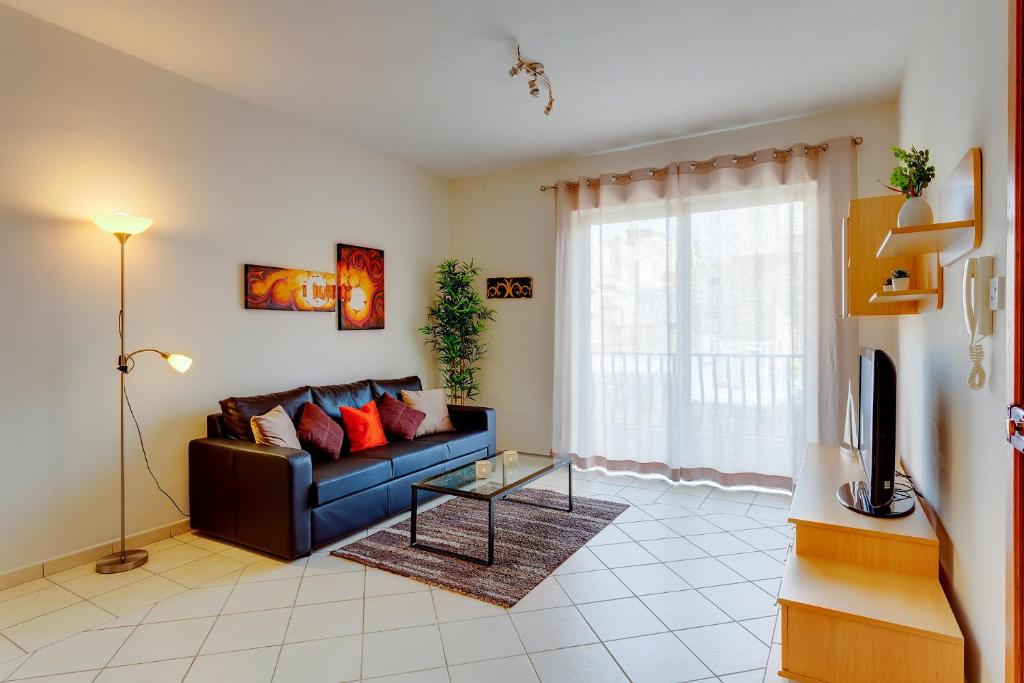 a living room with a couch and a tv at Spacious, Top Location Sliema Apartment in Sliema