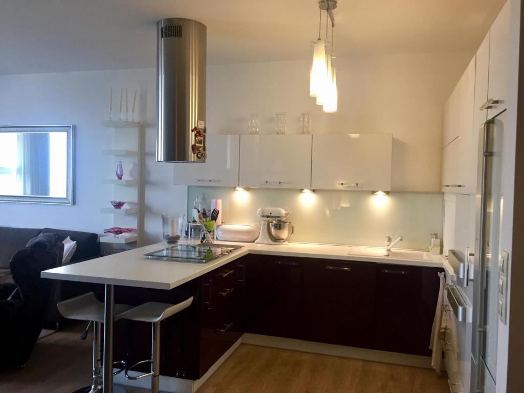 a kitchen with white cabinets and a white counter top at Cozy, beautiful view - 1 stop by train to old town in Bratislava