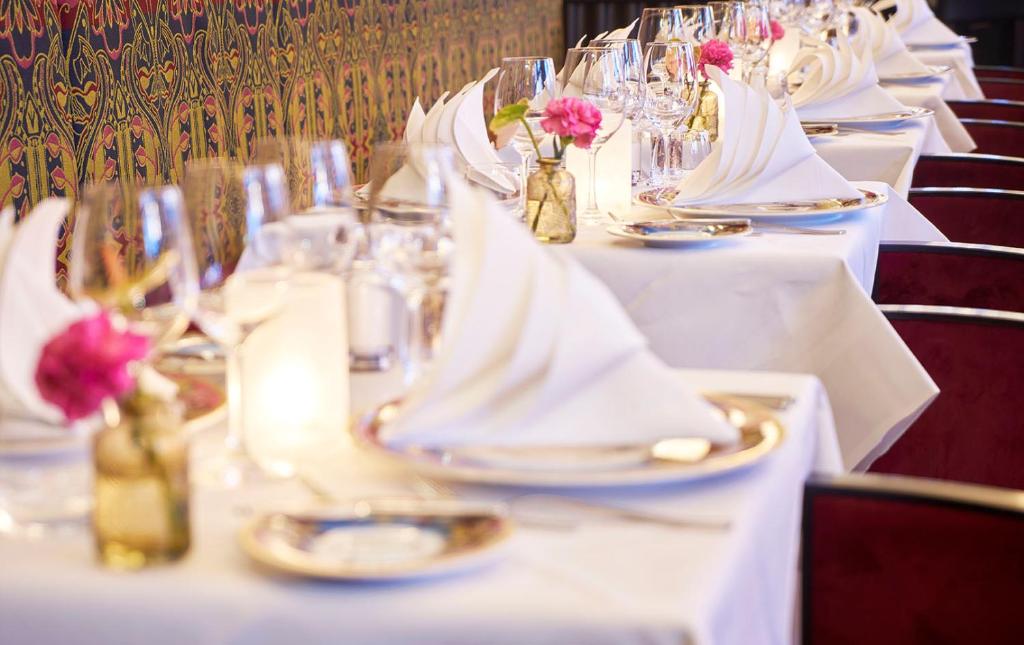 a long table with white tables with flowers on it at Grand Hotel Amrâth Amsterdam in Amsterdam