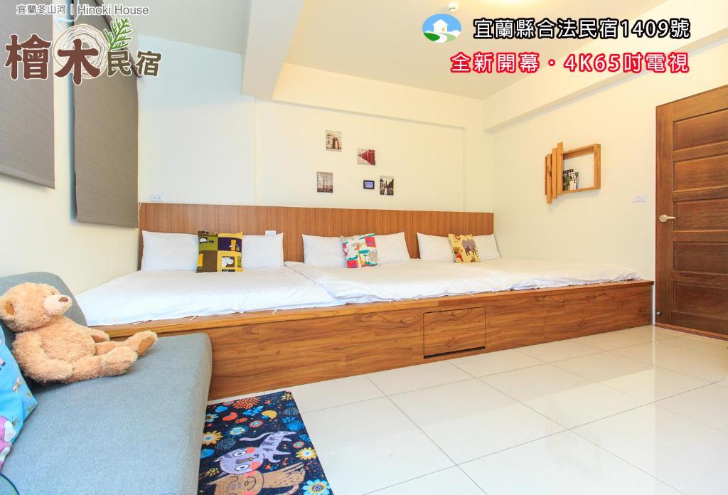 een slaapkamer met een groot houten bed en een teddybeer bij Yilan Dongshan Cypress B&B in Dongshan
