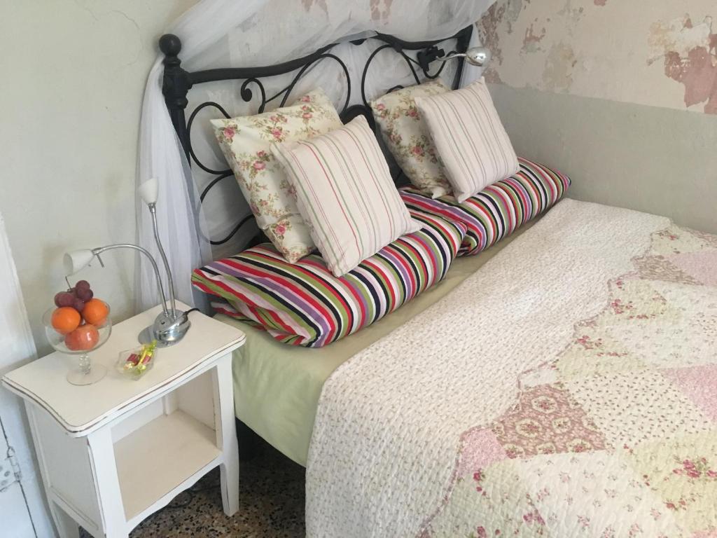 - un lit avec 2 oreillers et une table de chevet dans l'établissement Casa Rosalie, à Borgomaro