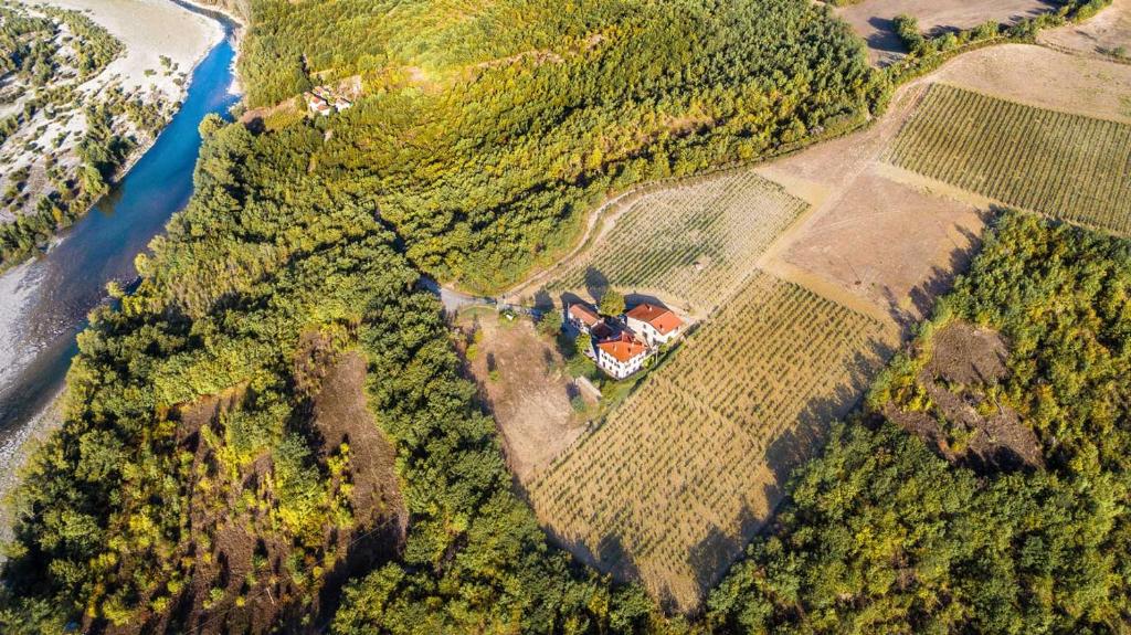 una vista aerea di una casa in una foresta vicino a un fiume di Agriturismo Ca' del Sartu a Bobbio
