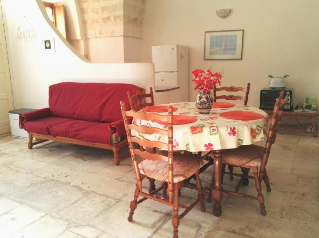 sala de estar con mesa y sofá rojo en Ostuni Centro en Ostuni