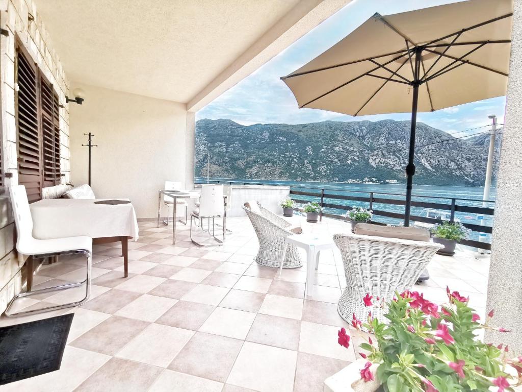 a patio with a table and chairs and an umbrella at Bay Terrace Apartment in Donji Stoliv