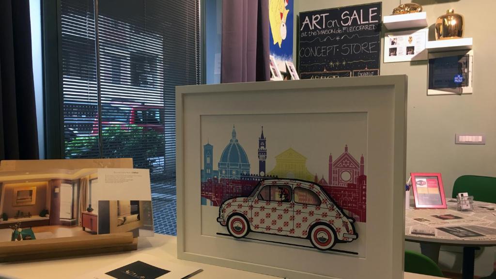 a picture of a car in a frame on a table at La Maison de Fuecopared in Florence