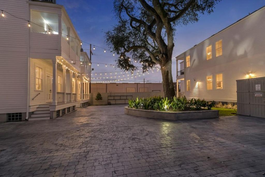 a courtyard with a tree in front of a building at Fabulous Cottages with City Views in New Orleans