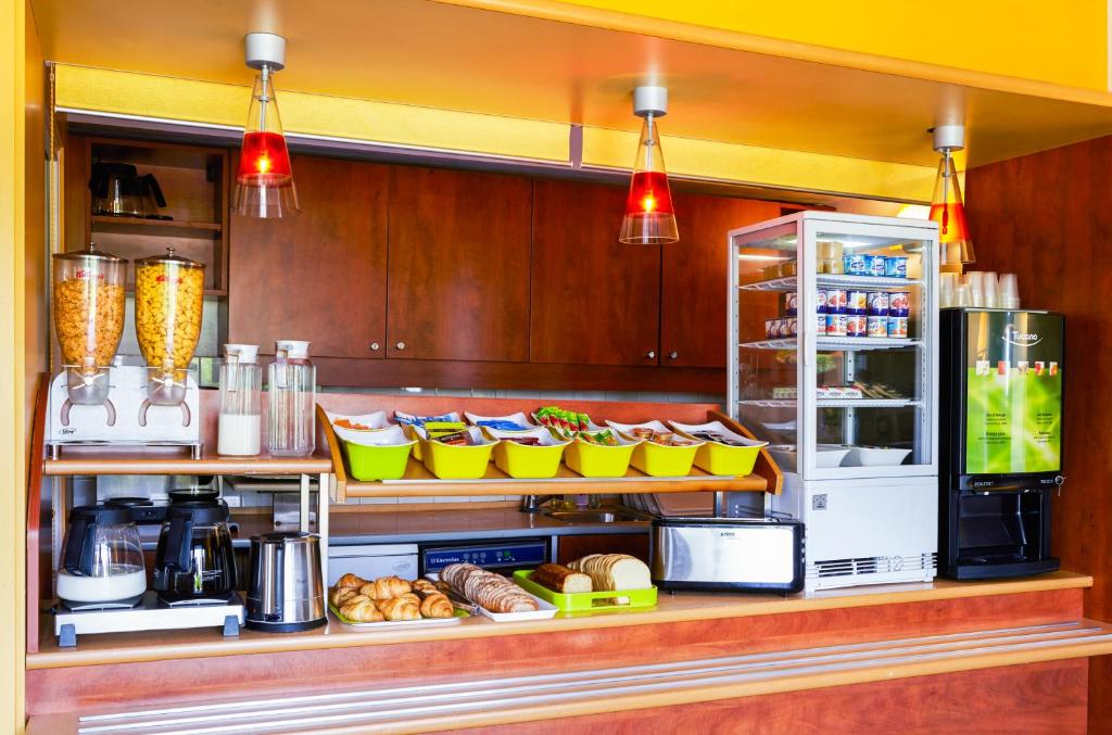 a kitchen with a counter with food and a refrigerator at ibis budget Chartres in Chartres