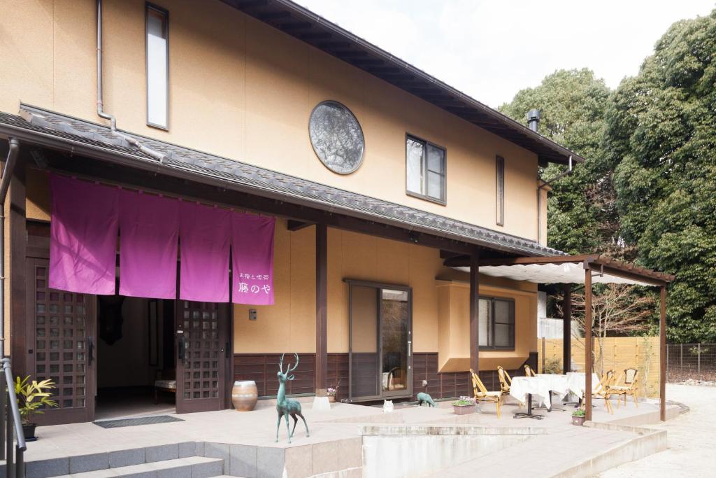 ein Gebäude mit einer Statue davor in der Unterkunft Miyajima Fujinoya Female Only in Miyajima