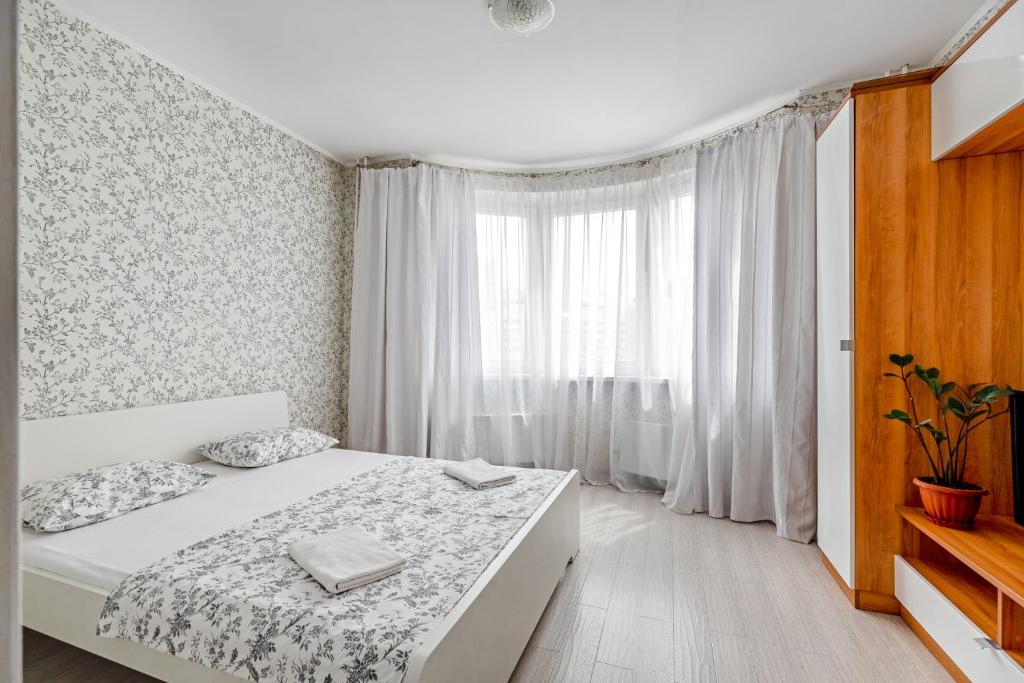 a white bedroom with a bed and a window at RentWill CROCUS 246 in Krasnogorsk