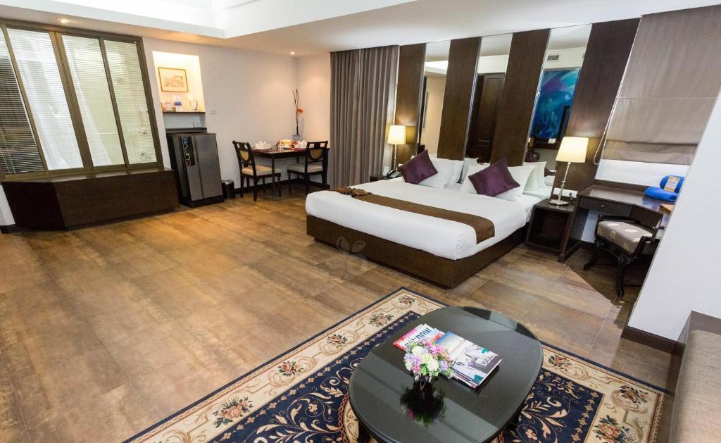 a large hotel room with a bed and a desk at The Grand Sathorn in Bangkok