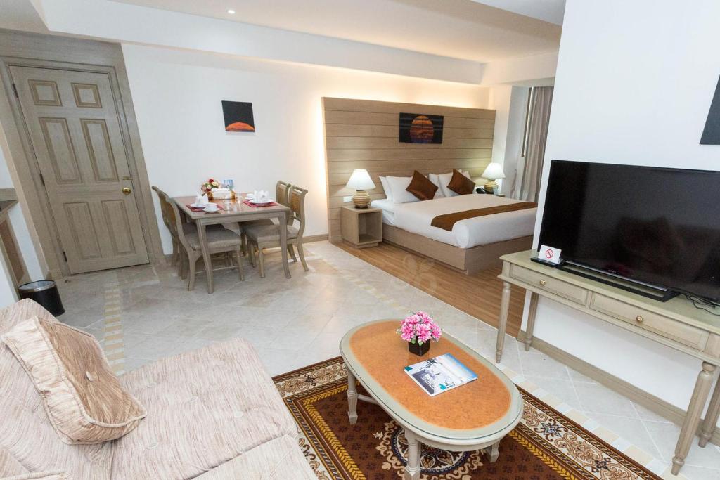 a large living room with a bed and a television at The Grand Sathorn in Bangkok
