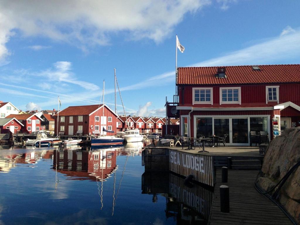 un puerto deportivo con un edificio rojo y barcos en el agua en Sea Lodge Smögen, en Smögen