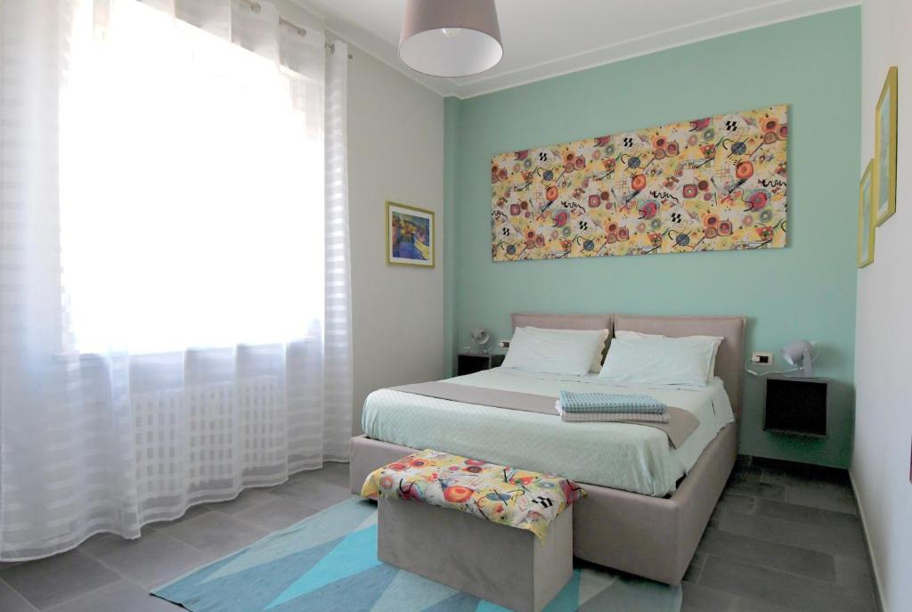トリノにあるTorino Comodo Al Centroのベッドルーム1室(ベッド1台付)が備わります。壁には絵画が飾られています。