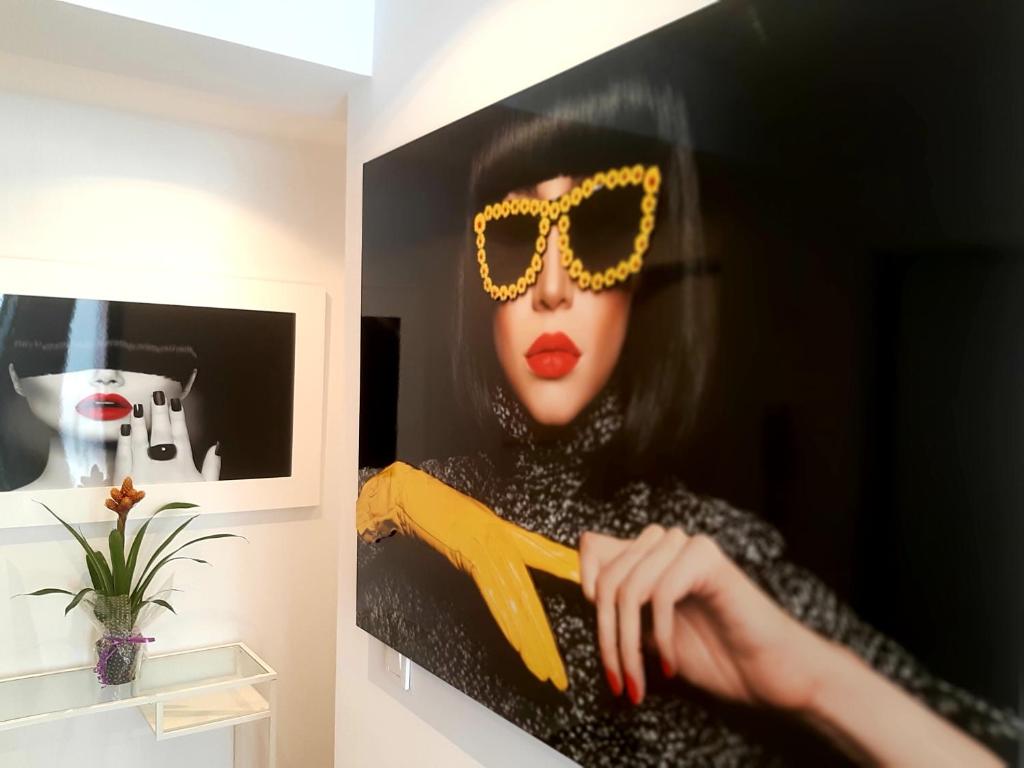 una pintura de una mujer con gafas de sol y un par de tijeras en Room Boutique 32 en Denia