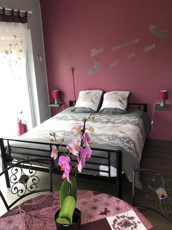 1 dormitorio con 1 cama con paredes de color rosa en La romance, en Le Breuil-en-Auge