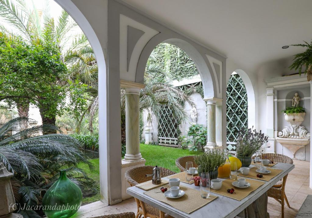 un patio con mesa y sillas y un jardín en Domus Lilia, en Viareggio