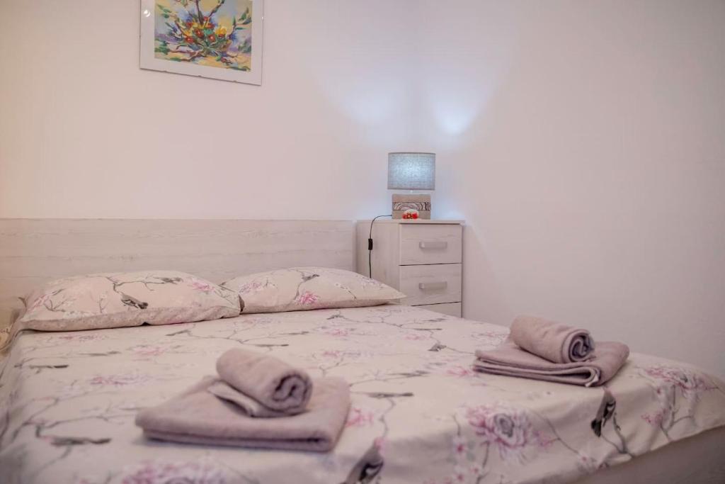 una camera da letto con un letto e asciugamani di Apartman Marcela a Rab