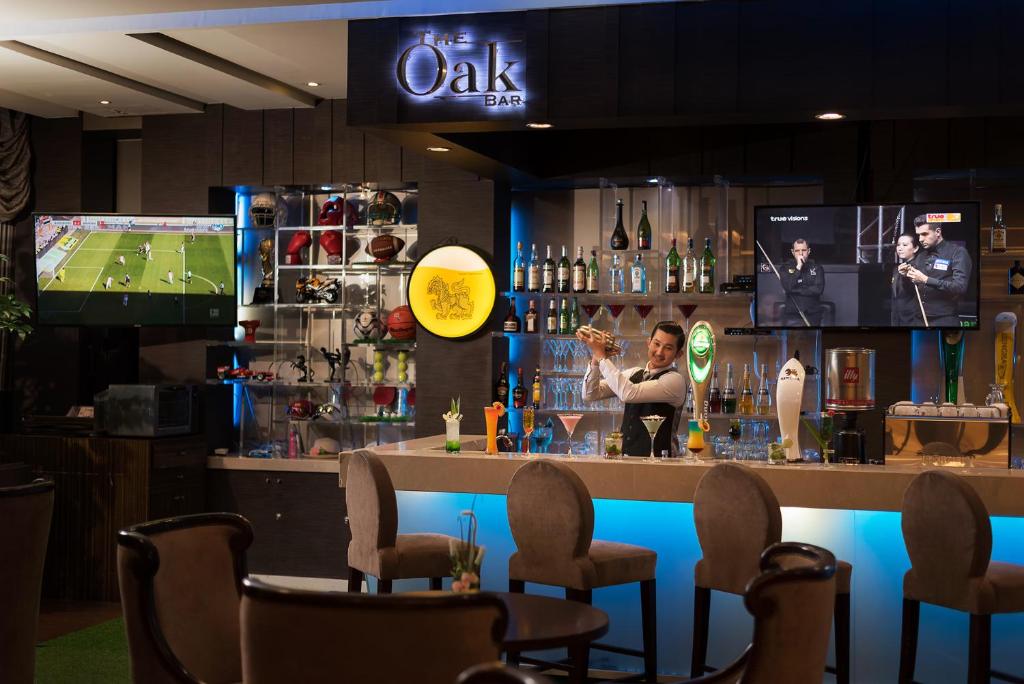 a bar in a restaurant with two televisions at The Berkeley Hotel Pratunam in Bangkok