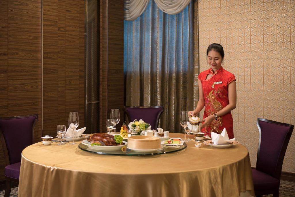 a woman standing in front of a table with food at The Berkeley Hotel Pratunam in Bangkok