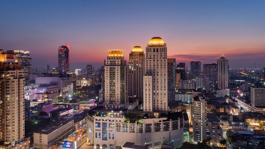 The Berkeley Hotel Pratunam - SHA Extra Plus في بانكوك: أفق المدينة مع المباني الطويلة في الليل