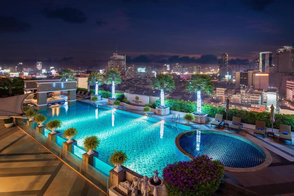 a swimming pool on the roof of a building at night at The Berkeley Hotel Pratunam in Bangkok